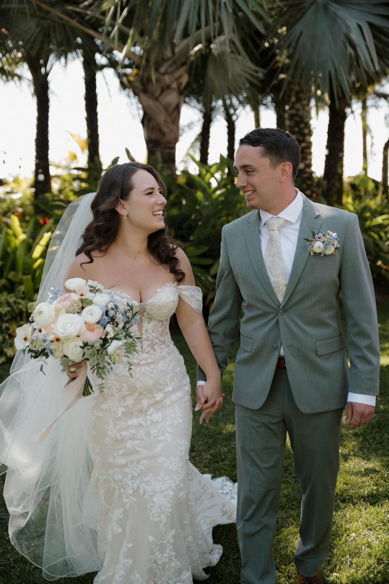 Bride holding a soft garden bouquet beside a groom wearing a boutonniere