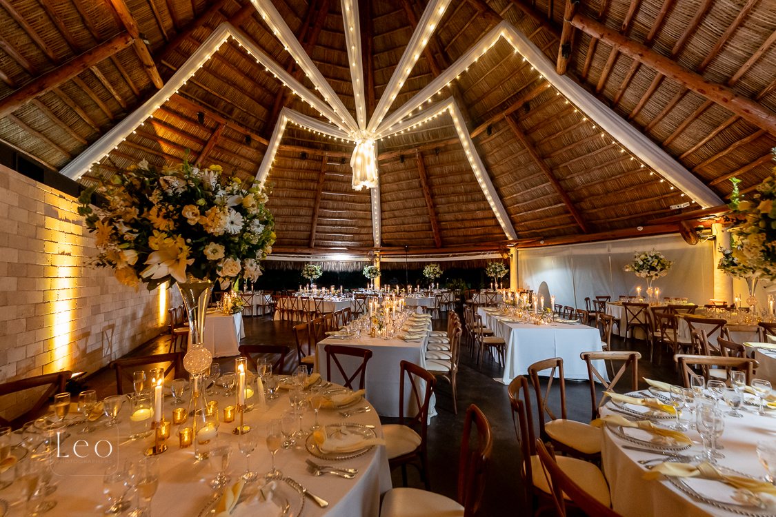 Romantic reception room filled with warm floral centerpieces